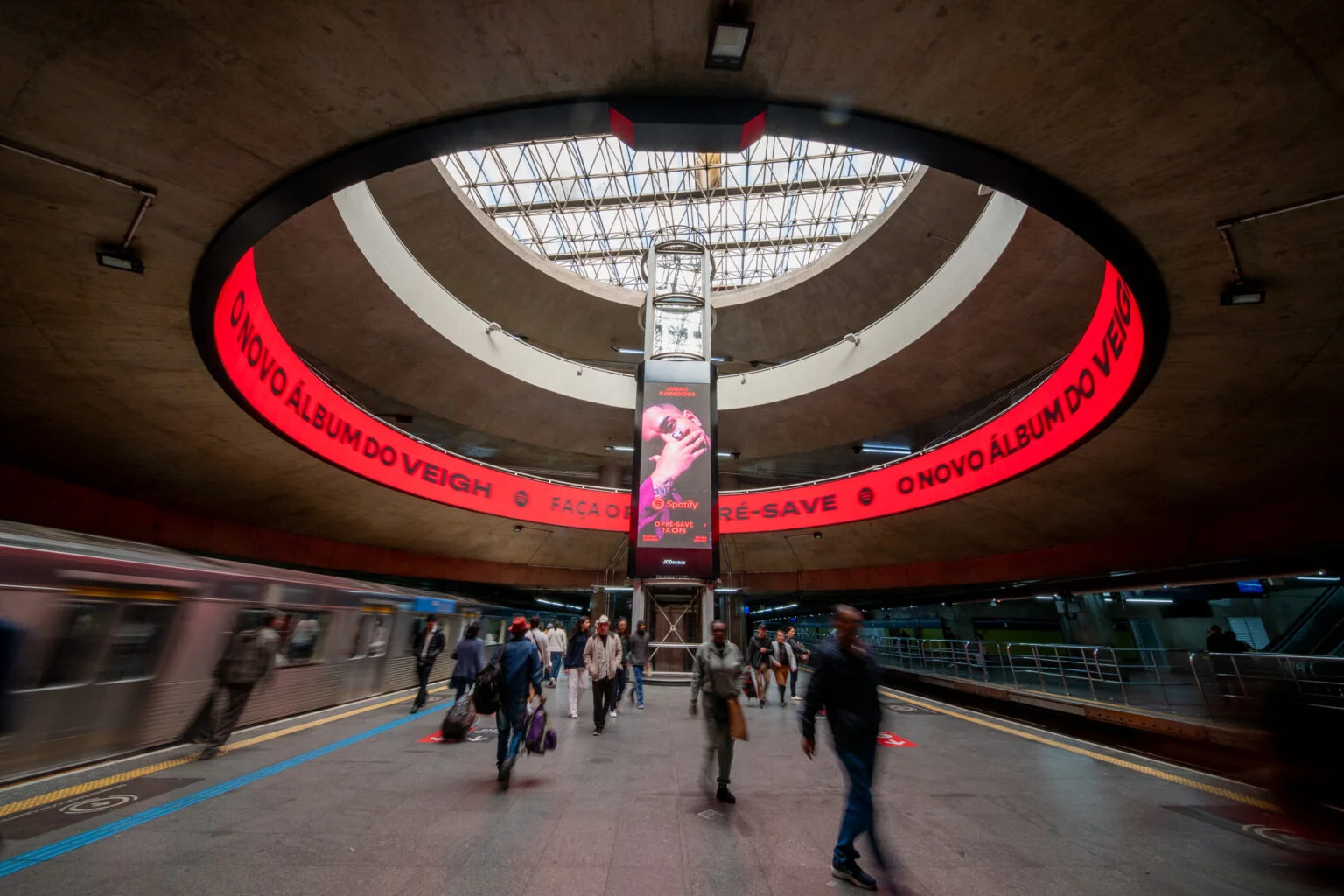 Anel de LED vermelho no teto de uma estação do metrô de São Paulo anunciando o novo álbum do Veigh